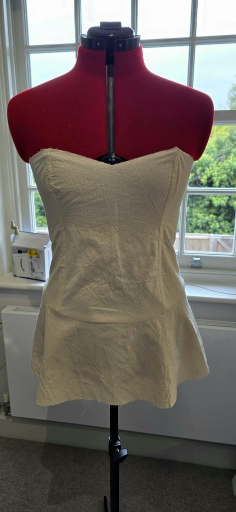 Babs dress form wearing a corselet shoulderless top with mini skirt