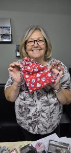 Beginner sewists displaying their finished drawstring bags.