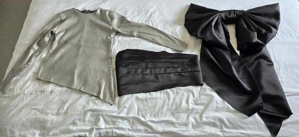 Handmade sequin bodice, matte satin hip panel, and oversized bow laid out before assembly for the Ophelia-inspired birthday dress.